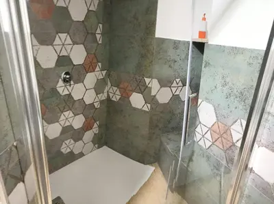 a bathroom with a shower with tiles on the wall at House Dotto 25 Apartment in Palermo