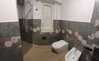a bathroom with a toilet and a sink and a window at House Dotto 25 Apartment in Palermo