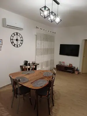 a dining room table with chairs and a clock on the wall at House Dotto 25 Apartment in Palermo