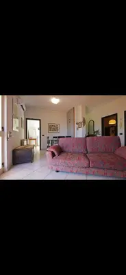 a living room with a red couch in a room at Casa Pizzillo in Campofelice di Roccella
