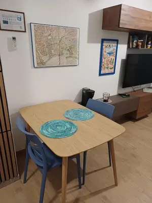 a wooden table with two chairs and a television at Dotto 25 Apartment in Palermo