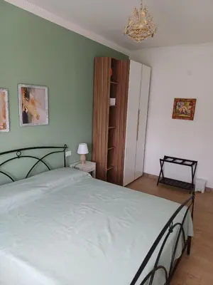 a bedroom with a large bed and a chandelier at Dotto 25 Apartment in Palermo