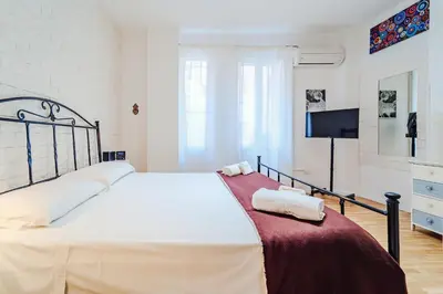 a bedroom with a large white bed with two towels at Sofia's House - Comfort e Relax vicino Stazione Notarbartolo in Palermo