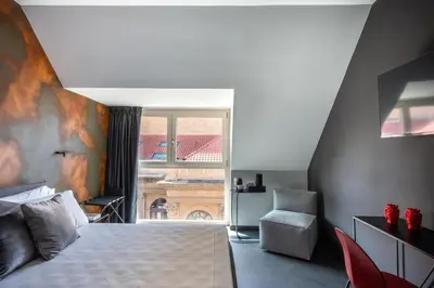 a bedroom with a bed and a window and a chair at Massimo Foyer 53 by Wonderful Italy in Palermo