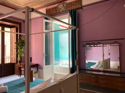 a room with a bedroom with pink walls and a mirror at Galleria Cutò - Art Boutique Rooms in Palermo