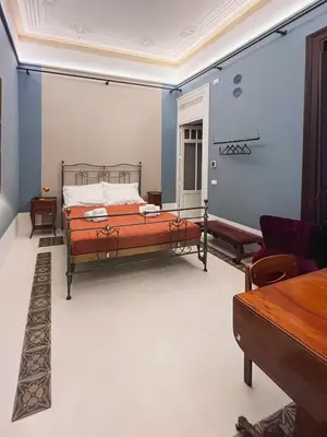 a bedroom with a bed in a room with blue walls at Galleria Cutò - Art Boutique Rooms in Palermo