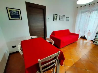 a living room with a red table and a red couch at Casa Marite' in Palermo