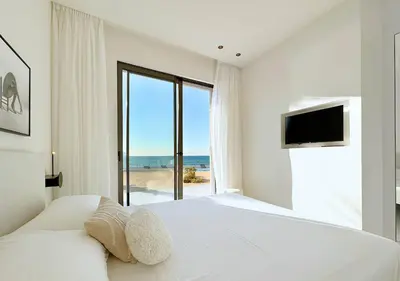 a white bedroom with a large bed and a television at Solemar Sicilia - Villa Gloria in Ficarazzi