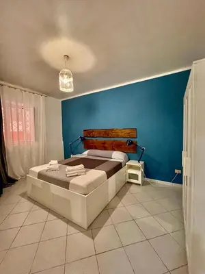 a bedroom with a bed and a blue wall at Scala Dei Normanni in Palermo