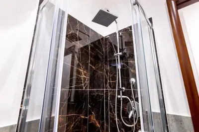 a shower stall with a glass door with a sink at Balarm-Boutique Rooms in Palermo