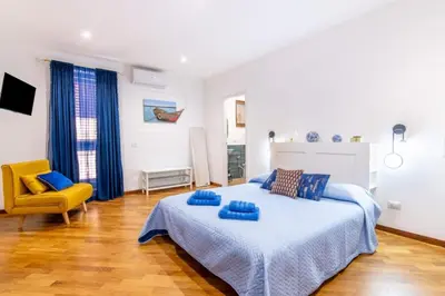 a bedroom with a large bed and a yellow chair at Balarm-Boutique Rooms in Palermo