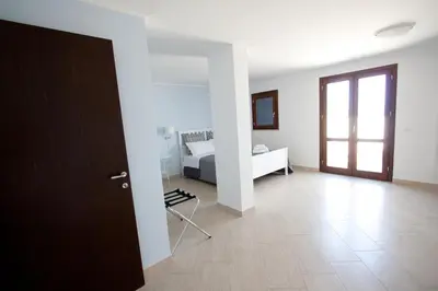a white room with a bed and a window at Casa Oltremare UnmarediBlu in San Vito lo Capo
