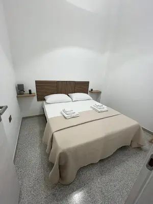 a bedroom with a large bed in a white room at D'Aversa Rooms in Marineo