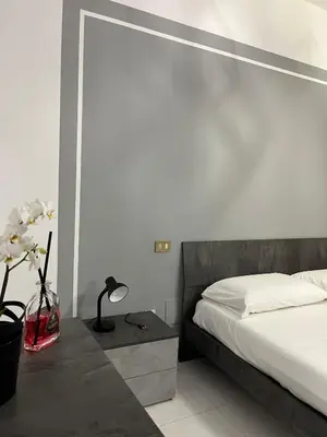 a bedroom with a bed and a table with a lamp at D'Aversa Rooms in Marineo