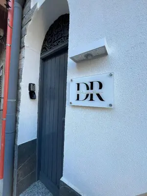 a sign on the side of a building with a door at D'Aversa Rooms in Marineo