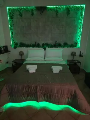 a bedroom with a large bed with green lights at Monreale Prestige Rooms B&B in Monreale