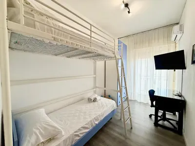 a bedroom with a bunk bed with a desk and a ladder at La Coccola in Palermo