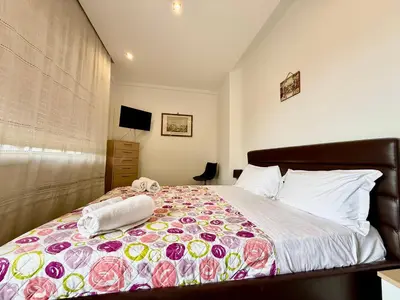 a bedroom with a bed with a floral bedspread at La Coccola in Palermo
