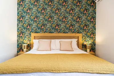 a bedroom with a large bed with a floral wallpaper at Casa D'Acquisto in Santa Flavia
