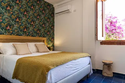 a bedroom with a bed with a floral wall at Casa D'Acquisto in Santa Flavia