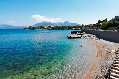 a beach in the water with people on it at Vicolo a Mare in Porticello