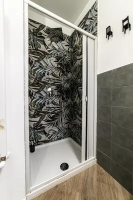 a shower in a bathroom with a black and white wallpaper at Casa Mazzarino - Exclusive Vucciria Apartment in Palermo