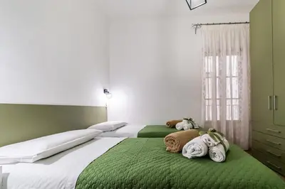 two beds in a bedroom with green and white at Casa Mazzarino - Exclusive Vucciria Apartment in Palermo