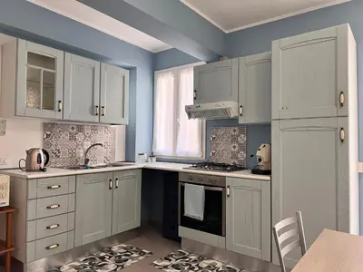 a kitchen with white cabinets and a stove top oven at M'AMA apartment 3 in Ficarazzi