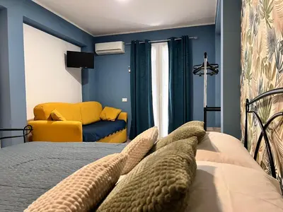 a bedroom with a bed and a yellow chair at M'AMA apartment 3 in Ficarazzi