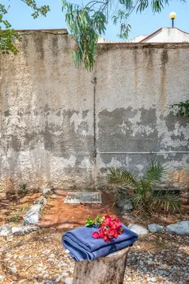 a table with flowers on it next to a wall at Isola delle Femmine Apartments by Wonderful Italy in Isola delle Femmine
