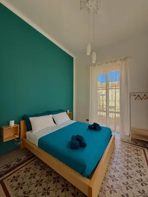 a bedroom with a large bed with a blue wall at Urban Space 49 in Palermo