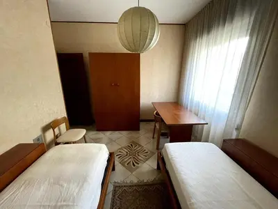 a room with two beds and a desk and a table at Palermo Home in Palermo
