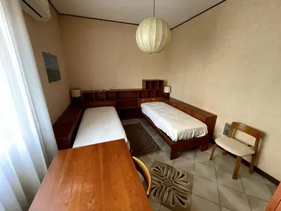 a small room with two beds and a table at Palermo Home in Palermo