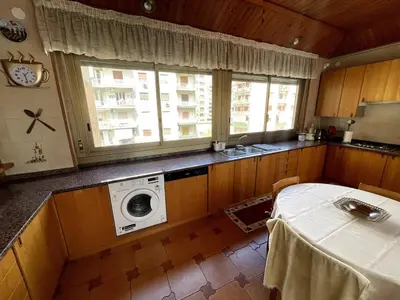 a kitchen with a washing machine and a table at Palermo Home in Palermo