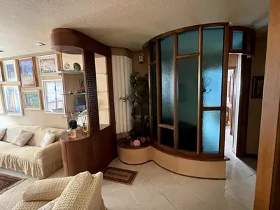 a living room with a couch and a large window at Palermo Home in Palermo