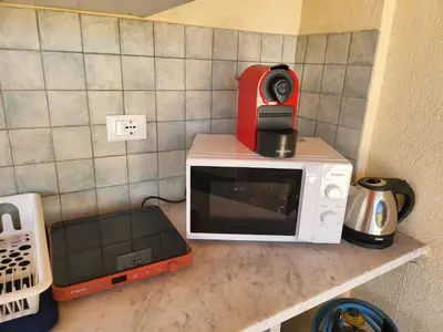 a microwave with a coffee maker on top of it at Le Case di Sole San Vito Lo Capo in San Vito lo Capo