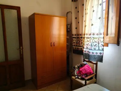 a bedroom with a wooden cabinet and a bed at Le Case di Sole San Vito Lo Capo in San Vito lo Capo