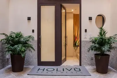 a hotel lobby with two potted plants in front of a door at Holivù Apartments in Palermo