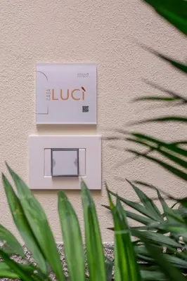 a glucose meter on the side of a wall with a plant at Holivù Apartments in Palermo