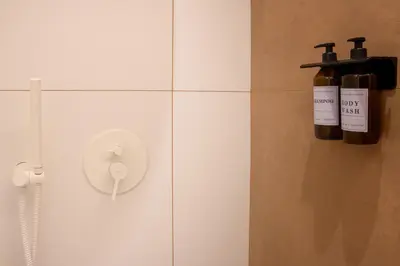a bathroom with two bottles of wine on the wall at Holivù Apartments in Palermo
