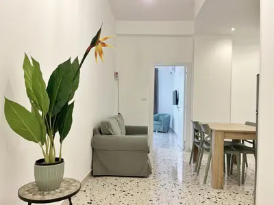 a living room with a chair and a table with a plant at Palermo central stay in Palermo