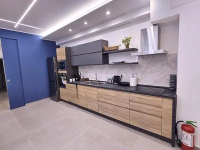 a kitchen with wooden cabinets and a blue wall at Al Centro di Palermo - Casa Bertolino in Palermo