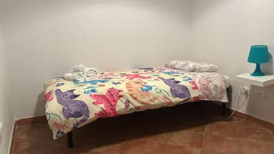 a bed with a comforter and a stuffed animal on it at La Casa di Cat in Palermo
