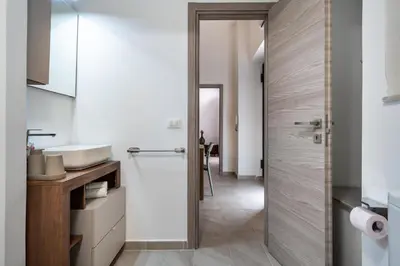 a bathroom with a sink and a glass shower door at Loft San Basilio in Palermo