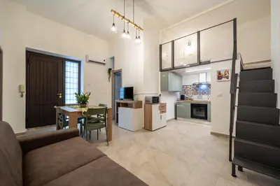 a living room and kitchen with a couch and a table at Loft San Basilio in Palermo