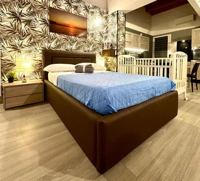 a bedroom with a large bed with a blue comforter at Casa Luma Palermo in Palermo