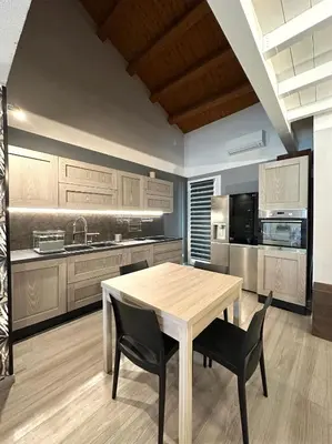 a kitchen with a wooden table and black chairs at Casa Luma Palermo in Palermo