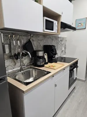 a kitchen with a sink and a microwave at La Mantia Luxury Rooms in Palermo