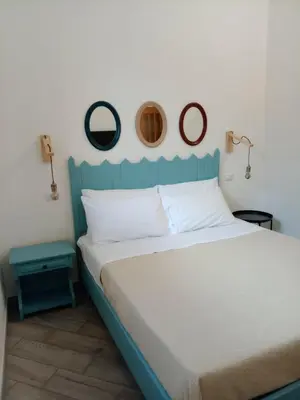 a bed with a blue headboard in a bedroom at Blu di Sicilia in Palermo