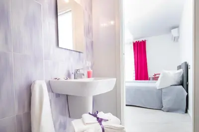 a white bathroom with a sink and a tub at Stanze del Mare in Balestrate